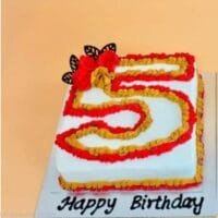 Egg-free number 5 birthday cake decorated with red and gold cream piping, floral decorations and chocolate accents.