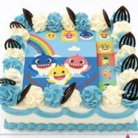 Baby Shark photo birthday cake with edible image, blue and white fresh cream rosettes, and chocolate leaf decorations