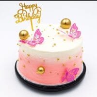 Round Egg Free pink ombre celebration cake decorated with butterfly toppers, edible gold pearls, gold spheres and a Happy Birthday topper.