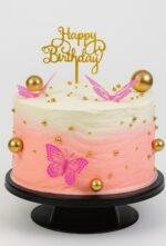 Butterfly Bloom Celebration Cake pink Birthday cake decorated with Butterfly, gold spheres, edible pearls and golden happy birthday topper