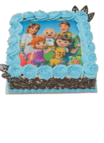 Egg Free Family Cartoon Photo Cake with an edible character image, blue cream swirls, chocolate curl sides and decorative chocolate leaves.