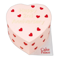 Pink heart anniversary cake with red heart decorations and custom message