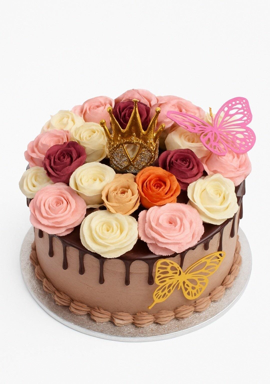 Elegant Chocolate Fresh Cream Rose Cake with Crown Round chocolate fresh cream cake decorated with chocolate drip, handcrafted fresh cream roses in pink, ivory, burgundy, peach and orange, a golden crown topper, and butterfly decorations.
