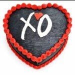 Heart-shaped fresh cream cake with a black finish, red piped border, and personalised XO message.