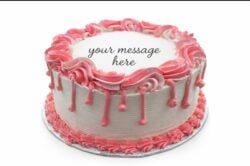Round white fresh cream birthday cake with pink drip decoration, pink piped borders, textured sides, and a personalised message.