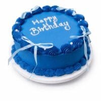 Top view of a royal blue fresh cream birthday cake featuring shell borders, white ribbon bows, pearl accents, and custom birthday writing.