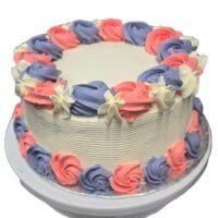Round fresh cream cake decorated with pink and lavender fresh cream rosettes, white floral accents, textured white sides, and space for a personalised message.