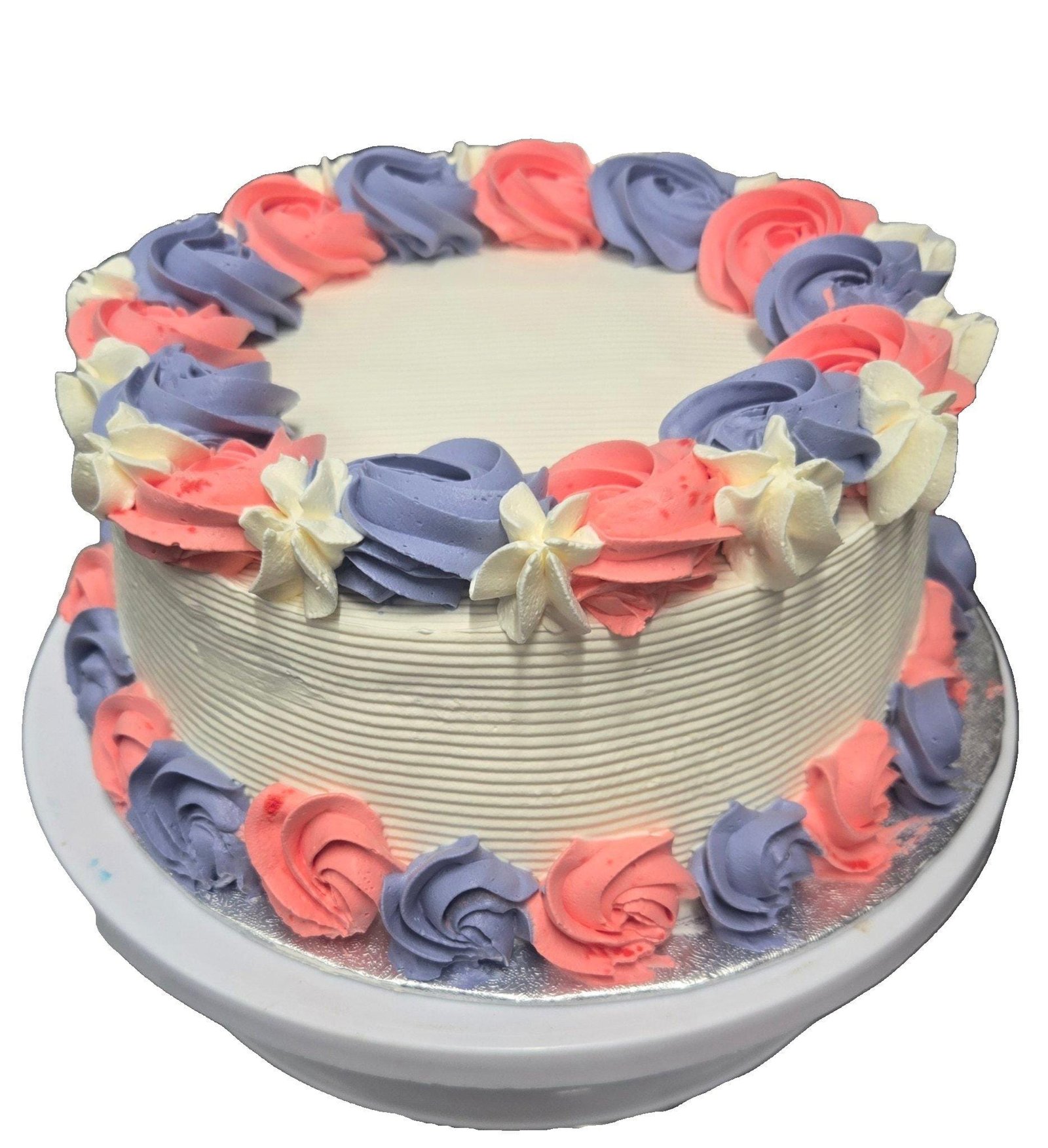 Pink & Lavender Fresh Cream Celebration Cake Round fresh cream cake decorated with pink and lavender fresh cream rosettes, white floral accents, textured white sides, and space for a personalised message.