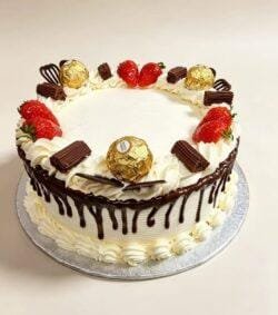 Chocolate drip celebration cake with fresh cream icing, chocolate ganache drip, fresh strawberries, Ferrero Rocher chocolates, chocolate curls, chocolate sticks and chocolate decorations, round birthday cake with space for personalised message, Cake Palace UK.