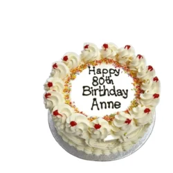 Round classic celebration cake with smooth fresh cream icing, piped cream rosettes, rainbow sprinkles, glazed cherries and personalised birthday message, traditional handmade celebration cake by Cake Palace UK.