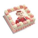 Personalised square birthday cake with a custom edible photo printed on top, finished with pink and white piped swirls around the border, smooth white icing finish, and matching pink piped base trim. Ideal for birthdays, children's parties, anniversaries, baby celebrations, and personalised cake gifts.